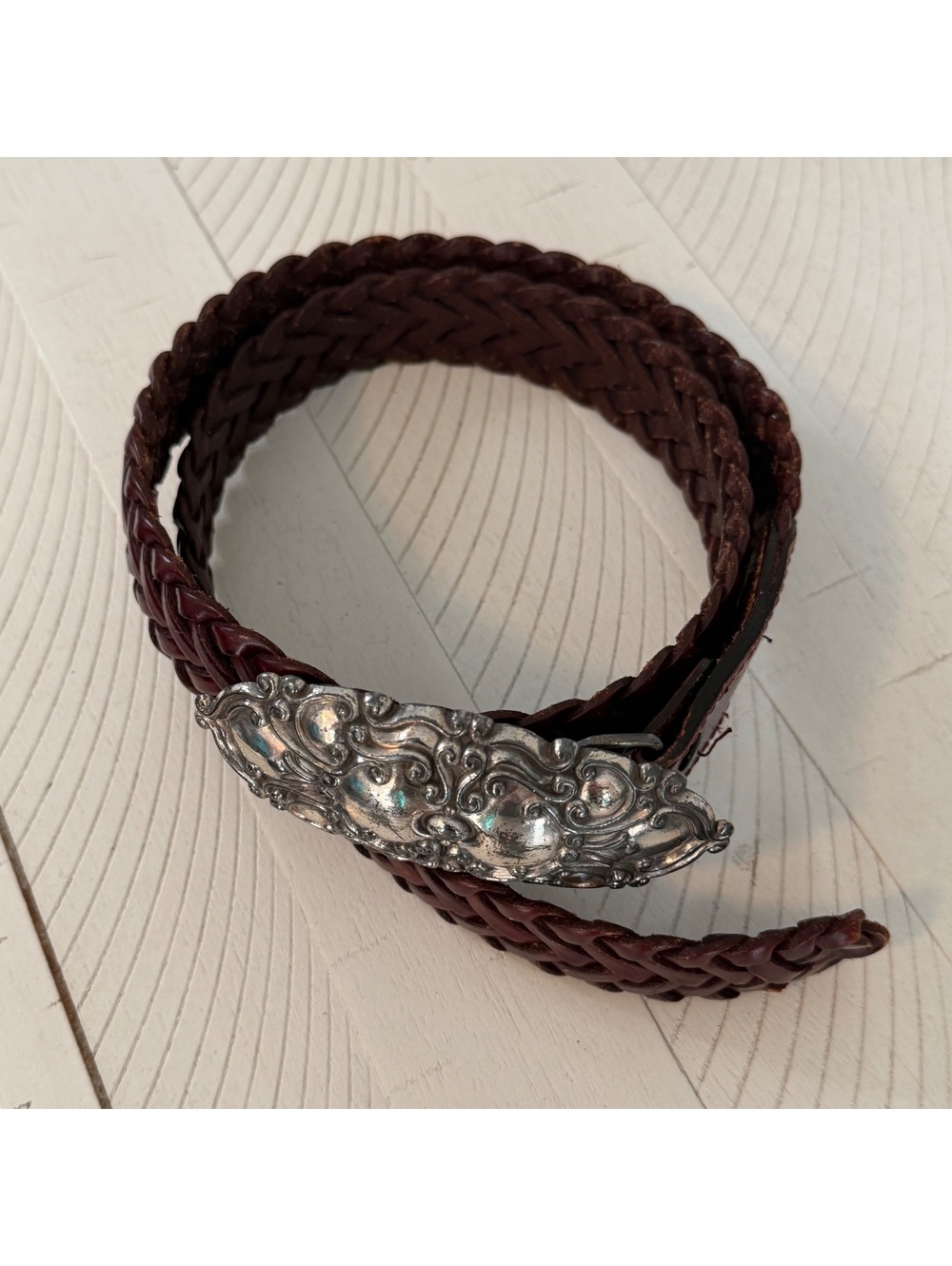 Ornate silver buckle brown braided belt